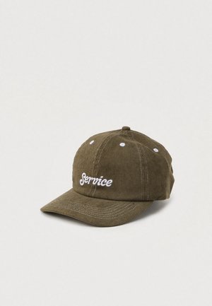 Gorra de pana verde oliva con visera curva, que presenta un logotipo bordado en blanco que dice "Service" y seis ojales blancos en la parte superior.