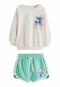 Sweatshirt beige chiaro con una grafica di Stitch e Angel, abbinato a pantaloni corti verde menta che presentano gli stessi personaggi e dettagli bianchi.