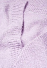 Pull en cachemire violet clair avec un col en V et des bords côtelés, présentant une texture douce et une finition lisse.