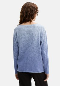 Langärmliges Hemd mit blauem Farbverlauf, aus weichem Stoff, mit rundem Ausschnitt und strukturierter Musterung, sichtbar genäht am Saum.