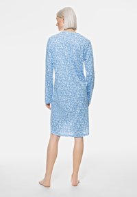 Nuisette à manches longues bleu clair avec un motif floral, col rond et silhouette décontractée, atteignant la mi-mollet.