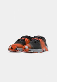 Black and orange athletic shoes with patterned laces and multicolored soles positioned side by side on a white background.