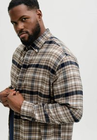 Karierter Hemd in Beige, Marineblau und Weiß. Mit Button-Down-Kragen, langen Ärmeln und lässiger Passform. Aus gewebtem Stoff gefertigt.