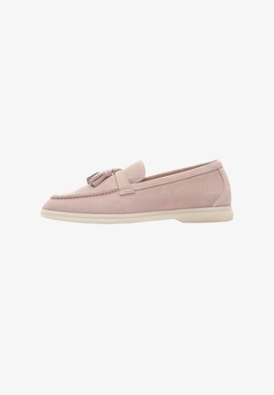 Zapato de ante rosa claro tipo deslizante con puntera redondeada y acento de borlas. Presenta una textura suave y una suela de goma beige.