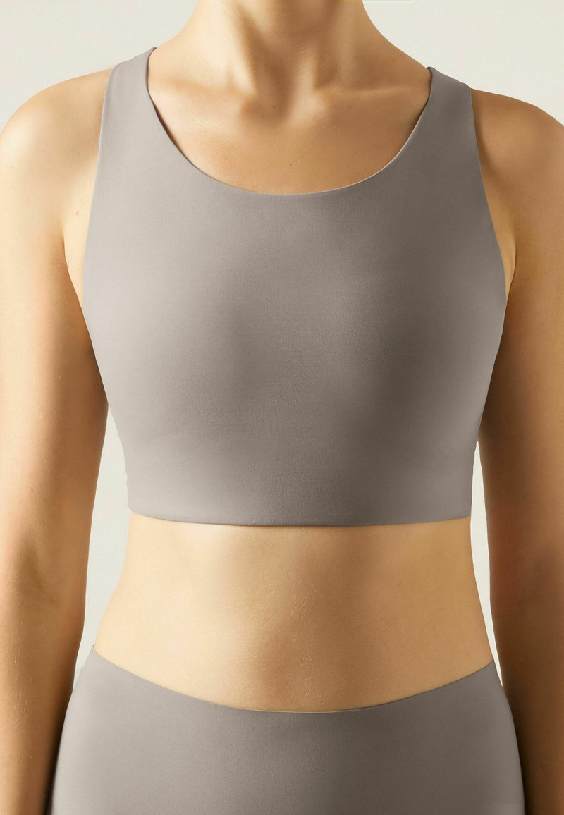Grauer Sport-Bralette mit rundem Ausschnitt und breiten Trägern, aus glattem, dehnbarem Stoff, entworfen für Komfort und Unterstützung.