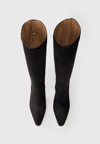 Térdig érő fekete velúr csizmák hegyes orral és sima barna béllettel, melyek tetején cipzáras záródás található.