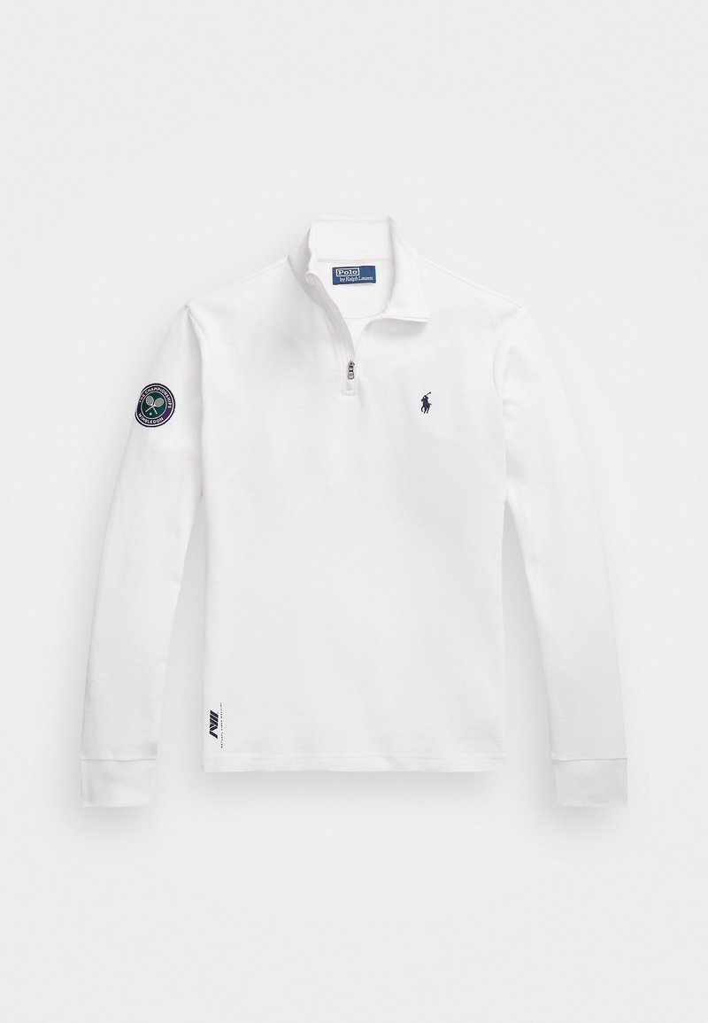 Hvid langærmet polo t-shirt med lynlås krave, med et marineblåt logo på brystet og et Wimbledon patch på ærmet. Stoffet er glat.