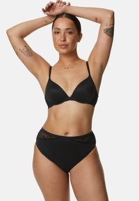 Zwart lingeriesetje met een gladde, gevoerde beha met dunne banden en hoogwijde slips met kantaccenten langs de taille.