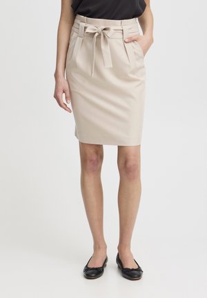 Falda lápiz beige con cinturón de lazo, parte delantera plisada y textura suave. Combinada con bailarinas negras. Diseño sencillo y ajustado.