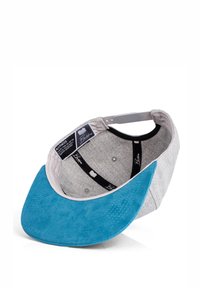 Hallikas müts, millel on teal värvi sametist visor. Sees on hall vooder ja must riba. Silt on nähtav brändi detailidega.