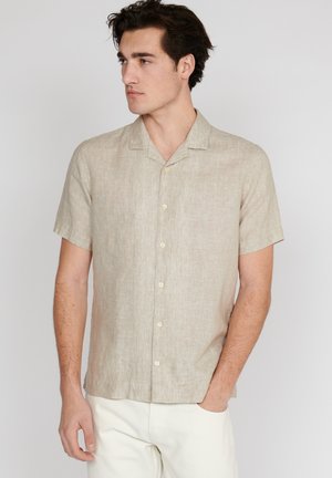 Camisa de lino beige de manga corta con botonadura frontal, cuello acampanado y corte relajado. Textura ligera, tejido suave y diseño simple.