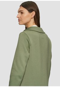 Grüner Sweatshirt mit Kragen, das eine glatte Textur und einen maßgeschneiderten Schnitt aufweist. Die Rückseite hat eine horizontale Nahtdetails über den Schultern.