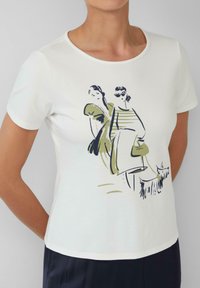 Witte T-shirt met korte mouwen, voorzien van een grafisch ontwerp van twee figuren in groen en zwart. Zachte stof met een ronde halslijn en een getailleerde pasvorm.