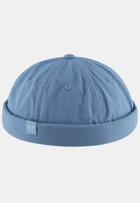 Gorro de algodón azul con una corona redondeada, visera ajustada y tejido texturizado. Presenta detalles de costura y una etiqueta con el logotipo en el lado.