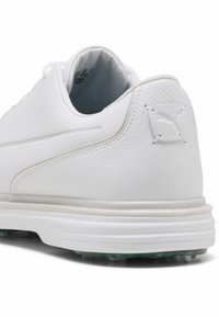 Λευκό δερμάτινο τακούνι αθλητικού παπουτσιού με υφή λεπτομέρειας και ανάγλυφο λογότυπο Puma στο πίσω μέρος, με μαλακή σόλα και αγκίστρια κάτω από αυτή.