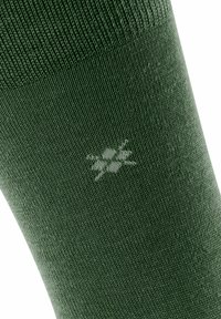 Calzino verde con un motivo a maglia testurizzato, con un piccolo dettaglio del logo bianco vicino alla caviglia. Il materiale sembra morbido ed elastico.