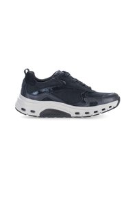 Zapatilla negra con detalles de ante y acentos brillantes, con una suela intermedia blanca gruesa, punta redondeada y secciones perforadas para ventilación.