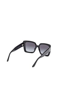 Gafas de sol negras en forma cuadrada con lentes grises degradados, montura de plástico brillante y lados negros texturizados. Presentan sutiles acentos metálicos.