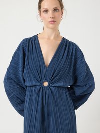 Mörkblå veckad klänning med djup V-ringning, samlad midja med utskuren rund detalj och vida, strukturerade ärmar.