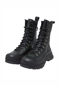 Botas de senderismo de cuero negro con diseño de tobillo alto, ojales de metal, cordones gruesos y suelas de goma resistentes para tracción. Detalle de cremallera en el costado.