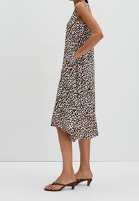 Blomstermønstret kjole med løs pasform, lavet af letvægtsstof, med lommer, V-udskæring og håndklæde-kant, i brune og cremede nuancer.