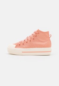 Högstövlad sneaker i mjukt rosa tyg, med en vit gummitå, platta snören och en texturerad yta med rosa accentlinjer.
