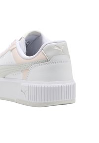 Zapatilla Puma blanca y rosa claro mostrando la parte trasera y lateral con suela texturizada y el logo de Puma en el talón y en el mediopié.