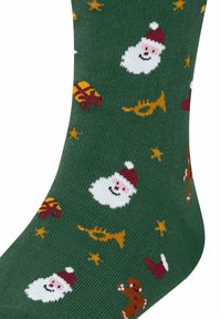 Calzini verdi con un motivo lavorato a maglia che rappresenta facce di Babbo Natale, regali, stelle, una tromba, un omino di pan di zenzero e stivali rossi. Materiale morbido ed elastico.