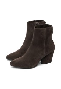 Botas de tobillo de ante marrón con punta afilada y una superficie ligeramente texturizada. Presenta un tacón grueso y un sutil detalle de costura.