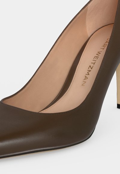 Escarpin en cuir marron à talon haut, bout pointu, intérieur beige et marquage visible sur la semelle intérieure.
