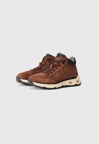 Scarpe alte in suede marrone con colletto imbottito, dettagli neri e suola ammortizzata con tasche d'aria per un supporto ottimale.
