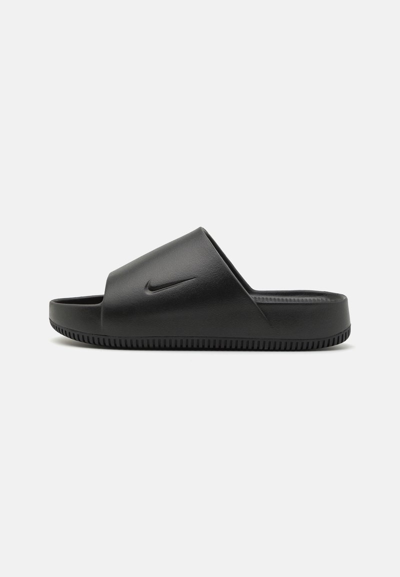 Sandale slide noire avec une large bride et une semelle basse, avec un petit logo swoosh en relief sur le côté extérieur.