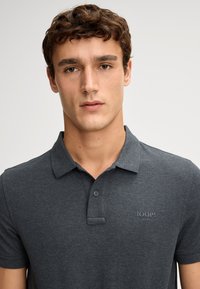 Dunkelgraues Polohemd mit Kragen, Zwei-Knopf-Leiste und eingeprägtem "JOOP! Jeans"-Logo auf der linken Brust. Aus Baumwoll-Mix.