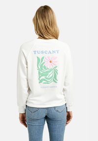 White sweatshirt with a colorful floral design featuring a pink flower, green leaves, and the text "TUSCANY FLOWER GARDEN" on the back.