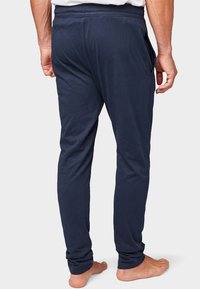 Jogging en bleu marine en coton doux, avec un design fuselé, une taille élastique et des poches latérales. Coupe décontractée.