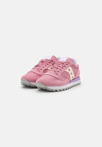 Rosa semskede sneakers med hvite detaljer, rund tå, flat grå såle og en lilla detalj som henger ned fra hælen. Har snøring og logo.