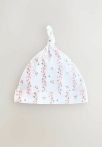 Bonnet bébé en coton blanc avec un motif floral rose et vert, doté d'un sommet noué et d'un bord large et replié. Texture douce.