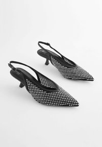 Mustat slingback-korkokengät, joissa on kapea kärki, koristeltu hopeisilla niiteillä tekstuuripinnalla, ja joissa on matala, kartiomainen korko.