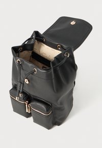 Schwarze Handtasche aus Kunstleder im Bucket-Stil mit einem Zugverschluss, zwei vorderen Reißverschlusstaschen und einem gemusterten Innenfutter.