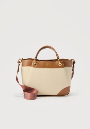 Sac fourre-tout en cuir crème et beige avec des poignées courtes, des ferrures dorées et une bandoulière en tissu rose détachable avec logo.