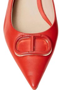 Scarpa piatta in pelle rossa con punta affusolata, dotata di una fibbia metallica decorativa sul davanti e di una soletta beige. Texture liscia complessivamente.