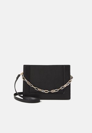 Bolso cruzado de piel negra con textura suave, forma rectangular y un detalle de cadena metálica en el frente. Incluye una correa ajustable.