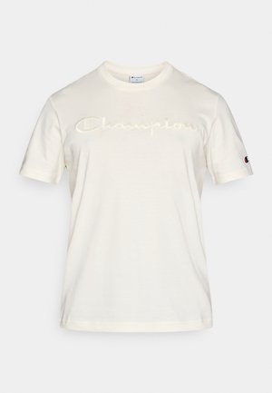 T-shirt de manga curta cor creme, feita de tecido macio, com o logótipo "Champion" bordado numa tonalidade ligeiramente mais escura na frente.