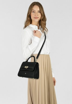 Schwarze Ledertasche mit strukturierter Gestaltung, ausgestattet mit einem oberen Griff, verstellbarem Schulterriemen, silberfarbenen Beschlägen und weißen Steppnähten.