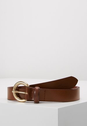 Bruine leren riem met een afgeronde gouden metalen gesp, opgerold en liggend op een wit oppervlak tegen een effen lichte achtergrond.