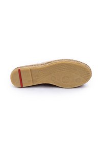 Suola di una scarpa con una base in gomma testurizzata di colore beige, accentuata da una striscia rossa e dettagli circolari.