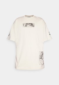 Bílé oversized tričko vyrobené z bavlny s černými grafickými potisky postavy na přední a boční straně, kulatý výstřih a krátké rukávy.