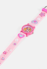 Reloj de silicona rosa con una esfera redonda que presenta un perro de dibujos animados. La correa tiene adornos de corazones y estrellas en varios colores y formas.