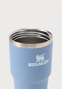 Cestovní hrnek z nerezové oceli s matně modrým povrchem, s stříbrným okrajem a vyraženým logem "STANLEY" s emblémem lva.
