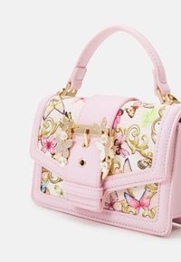 Pink handbag with butterfly print and gold hardware. Features a top handle, clasp closure, and decorative butterfly accents.